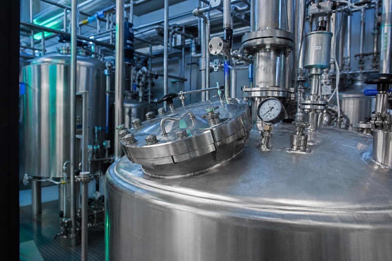 Stainless steel chemical tanks, valves, and piping at a processing plant